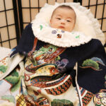 お宮参りの家族写真撮影。午前中はこの着物(産着)で鈴鹿市白子の子安観音様でお宮参りされたそうです。 スタジオバンビ鈴鹿/お宮参り写真撮影。黒の着物が似合っています。